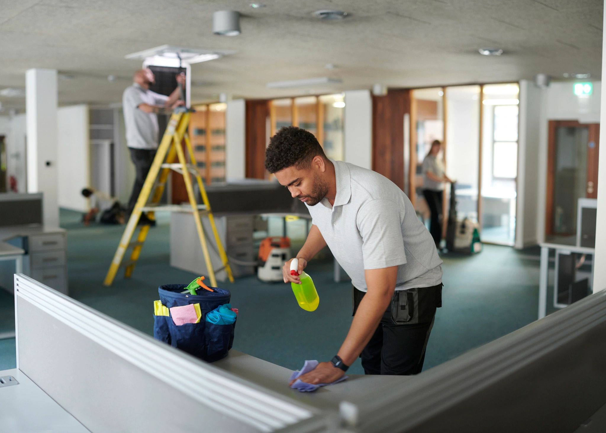 Professional cleaners working together in a bright office space